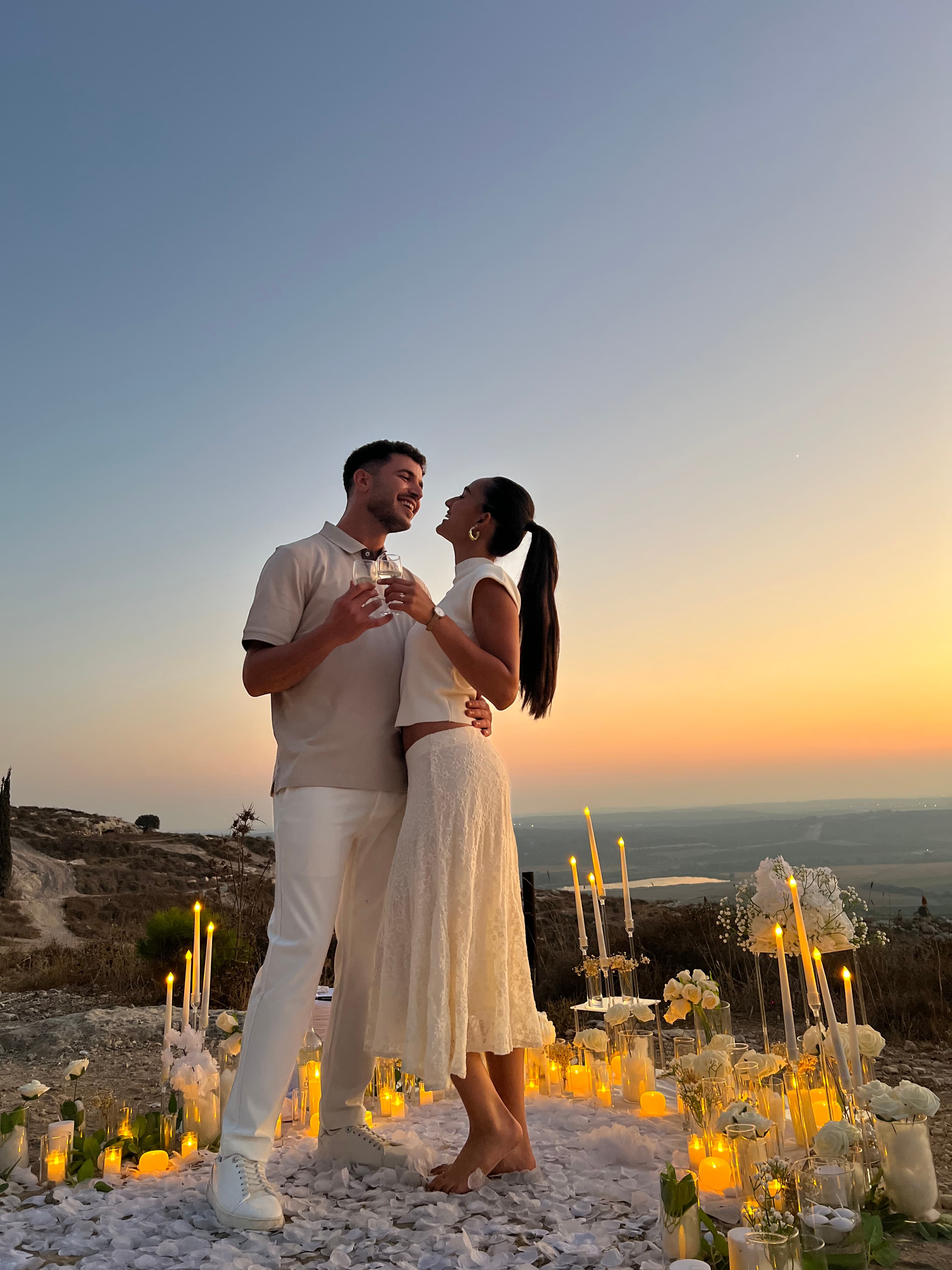 חושן ואביאל מרימים כוסית יין ברקע השקיעה בהרי ירושלים